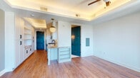 Located at 1301 Spring St NW in Atlanta's vibrant Midtown neighborhood, this thoughtfully designed single-floor residence combines modern aesthetics with refined functionality. The open-concept living area features warm wood-look flooring, tray ceilings with ambient cove lighting, and a ceiling fan, creating a bright and inviting atmosphere. Large floor-to-ceiling glass doors lead to a private balcony offering sweeping city views of the Atlanta skyline. The well-appointed kitchen is a standout, boasting granite countertops, white shaker cabinetry with matte black hardware, a subway tile backsplash, and stainless steel appliances including a gas range, microwave, and dishwasher. A spacious butler's pantry extends the kitchen's storage capacity with abundant open shelving, additional granite countertops, and its own pendant lighting — all framed by a door opening to the balcony. Bold teal-painted interior doors provide striking design accents throughout the space. The bedroom benefits from natural light via large windows and balcony access, complemented by a ceiling fan. The bathroom is finished with granite vanity counters, elegant tile work, and a soaking tub with an overhead shower. This unit delivers a polished urban living experience in the heart of Atlanta.