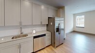 Located at 355 Walnut St in Chattanooga, TN, this multi-floor property spans three levels connected by a staircase with light wood-toned flooring throughout the common areas. The interior showcases a consistent, modern design palette with neutral walls, gray baseboards, and stylish two-panel gray interior doors.

The kitchen is thoughtfully designed with gray shaker-style cabinetry extending to the ceiling, granite countertops, a stainless steel undermount sink, and a full suite of stainless steel appliances including a French door refrigerator with ice and water dispenser, an electric range, built-in microwave, and dishwasher. Generous pantry-style cabinetry provides ample storage.

Living areas feature light hardwood-style flooring, ceiling fans, and windows that bring in natural light. Bedrooms are carpeted for comfort and include ceiling fans and walk-in closets fitted with wire shelving systems.

Bathrooms are finished with granite-topped gray vanities, white subway tile, and chrome fixtures. The primary bathroom offers a double-sink vanity with a large mirror and a tiled walk-in shower, while secondary bathrooms include a tub-shower combination. A dedicated laundry area houses a full-size washer and dryer. The layout and finishes make this a highly functional and attractive property.