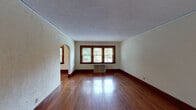 Located on Clifton Avenue in Cincinnati, OH, this single-floor residence blends classic architectural charm with functional living spaces. Rich, polished hardwood floors run throughout the main living areas, complemented by deep-toned wood trim, baseboards, and window casings that lend warmth and character to each room. A standout arched doorway connects the generously sized living and dining areas, creating an open, flowing layout filled with natural light from multiple windows. The textured ceilings add a traditional touch consistent throughout the home. Multiple bedrooms offer versatile living arrangements; most feature hardwood floors and wood-framed windows with views of the surrounding greenery, while one carpeted room includes a built-in closet with shelving. The kitchen is well-appointed with warm wood cabinetry, dark granite countertops, a gas range, dishwasher, double-basin sink, and tile flooring, along with a window that brings in natural light. The bathroom retains its classic aesthetic with a black-and-white mosaic hex tile floor, white subway tile walls accented by black trim, a soaking tub, and a modern floating vanity. Throughout the home, radiator units provide heating, underscoring its period character while maintaining everyday comfort.