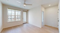 Located at 11805 Pioneers Way in Orlando, FL, this thoughtfully designed two-bedroom, three-bathroom residence offers a clean, modern aesthetic across a well-organized single-floor layout. The kitchen serves as a central highlight, featuring a large central island with pendant lighting, stainless steel appliances including a range, built-in microwave, and French door refrigerator, complemented by white upper cabinetry, soft gray lower cabinets, white countertops, and a classic subway tile backsplash. Light wood-style flooring flows consistently throughout the home, enhancing its bright and cohesive feel. The bedrooms are generously proportioned, each equipped with ceiling fans and large windows that invite abundant natural light and views of the surrounding community. The primary bedroom includes access to a walk-in closet with wire shelving and an en-suite bathroom featuring a single vanity with white countertop, a glass-enclosed shower, and matte black fixtures. A second full bathroom offers a tiled tub-shower combination with matching black hardware. An additional bathroom provides a sleek, fully tiled walk-in shower. Two dedicated closets ensure ample storage throughout the home, rounding out this well-appointed and move-in-ready Orlando residence.