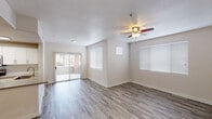 This single-floor residence offers a thoughtfully designed layout that balances open living spaces with functional private quarters. The main living area is bright and airy, featuring wood-look flooring throughout and multiple windows dressed with horizontal blinds that invite abundant natural light. A ceiling fan adds comfort to the space, while a sliding glass door opens to an outdoor area, seamlessly connecting interior and exterior living. The layout also includes a second living or dining area with matching flooring and additional natural light.

The kitchen is well-equipped with crisp white cabinetry, light-toned countertops, and a full suite of stainless steel appliances, including an electric range with overhead microwave and a sink with modern fixtures. The clean, neutral finishes give the kitchen a fresh, contemporary feel.

The bedrooms are carpeted for comfort and each features a ceiling fan with light fixture. The primary bedroom includes a walk-in closet and direct access to a private en-suite bathroom outfitted with white vanity cabinetry. A second bedroom offers a spacious sliding-door closet. Throughout the residence, neutral wall tones and consistent finishes create a cohesive and welcoming ambiance suitable for a variety of lifestyles.