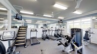 This fitness center offers a well-appointed workout environment designed to support a range of exercise routines. The space features a clean, open layout with light blue walls and a crisp white wainscoting detail that gives the room a bright, polished aesthetic. Large rectangular recessed light panels and a ceiling fan work together to ensure the space remains well-lit and well-ventilated throughout any workout session. Multiple windows along the walls allow natural light to filter in, enhancing the overall atmosphere. A full-length mirror spans one wall, creating a sense of added depth and allowing users to monitor their form during exercise. The cardio section is well stocked, featuring multiple treadmills and an elliptical cross-trainer lined neatly along the mirrored wall. Strength and resistance training equipment is also available, including a multi-function cable and weight machine positioned toward the perimeter of the space. A mounted flat-screen television provides entertainment during workouts. The durable, speckled carpet flooring is suited for high-traffic use, and the overall layout ensures comfortable circulation between equipment. A storage rack along one wall holds additional accessories or free weights. This fitness center provides a comprehensive and inviting environment for residents or members to maintain an active lifestyle.