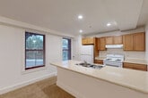 Located at 9619 Dewitt Dr in Silver Spring, MD, this single-floor residence offers three bedrooms, two full bathrooms, and a thoughtfully arranged layout. The combined kitchen and dining area serves as a central hub, featuring warm wood cabinetry, light countertops, a double-basin sink, and white appliances including a range and refrigerator. A peninsula counter provides additional workspace and separates the kitchen from the adjoining living area. Recessed lighting and multiple windows allow natural light to fill the space, offering views of the surrounding neighborhood greenery.

The living room is generously proportioned, finished with neutral carpeting and clean white walls that lend a bright, open feel. The primary bedroom benefits from a bay-style multi-window arrangement, bringing in ample daylight. Additional bedrooms are carpeted and well-sized, each with windows and convenient access to the hallways. Two full bathrooms are finished in a clean, functional style, each featuring a tub-shower combination, vanity with storage, and a window for natural ventilation. Throughout the residence, an impressive seven closets provide exceptional storage. The entrance and dual hallways ensure smooth flow between all areas of the home.