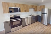 This 510 square foot apartment in Duluth maximizes space efficiency with a thoughtful open-concept design. The modern kitchen is a focal point, boasting stainless steel appliances, including a full-size refrigerator, oven, and dishwasher. Light wood upper cabinets contrast beautifully with darker lower cabinets, while a white subway tile backsplash adds a classic touch.

The living area flows seamlessly from the kitchen, featuring hardwood floors that extend throughout the apartment, creating a cohesive look. Large windows in the bedroom and living spaces allow ample natural light, brightening the neutral-toned walls.

The bathroom is equipped with a full-size tub-shower combination, a single vanity with storage, and a modern toilet. For added convenience, the unit includes an in-unit washer, tucked away in a dedicated laundry area.

Despite its compact size, the apartment doesn't compromise on functionality. Recessed lighting throughout provides even illumination, while the open layout creates a sense of spaciousness. This efficient design makes the most of the 510 square feet, offering a comfortable living space with all necessary amenities.
