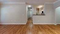 Located at 1100 Legends Club Dr in Mount Pleasant, SC, this single-floor residence offers a well-designed layout with a cohesive, neutral color palette throughout. The open living area features warm wood-look flooring, crown molding, a ceiling fan, and large windows that allow for generous natural light and outdoor views. The kitchen is equipped with stainless steel appliances, including a range, microwave, and dishwasher, complemented by dark stone countertops, white cabinetry, and a classic subway tile backsplash. A breakfast bar connects the kitchen to the main living space, enhancing the open flow of the floor plan. A central hallway with arched accents connects the living areas to the private quarters. The bedrooms are carpeted for comfort and each features windows that bring in natural light. The primary bedroom suite includes a spacious walk-in closet outfitted with built-in wire shelving for organized storage. The bathrooms are finished with white vanities, white countertops, wood-look flooring, and brushed nickel fixtures. One bathroom includes a tub-shower combination with tiled surround, while a second bathroom offers a dedicated shower area. The overall ambiance is clean, bright, and move-in ready.