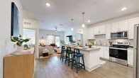 Located at 725 Flagler Crossing Dr in St. Augustine, FL, this well-appointed single-story home offers two bedrooms, three bathrooms, and a thoughtfully designed open-concept layout. The kitchen is a standout feature, showcasing white shaker cabinetry, subway tile backsplash, granite countertops, stainless steel appliances, and a large peninsula island with bar seating — all flowing seamlessly into the bright living room, which is filled with natural light from large windows. Wood-look flooring runs throughout the main living areas, adding warmth and continuity. The primary bedroom is a comfortable retreat, carpeted for comfort, with multiple windows, a ceiling fan, and access to a dedicated closet. The bathrooms are finished with granite vanity tops and wood-look tile flooring; one features a full soaking tub with clean white subway tile surround and brushed nickel fixtures. A second closet provides additional storage. The dedicated in-unit laundry room houses a full-size washer and dryer with overhead shelving. Every room reflects a clean, modern aesthetic with a neutral palette, making this home a functional and inviting space in the heart of St. Augustine.