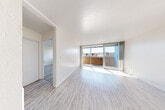 Located at 1321 Marshall St in Redwood City, California, Unit 403 is a thoughtfully laid-out single-floor residence that makes excellent use of its compact footprint. The interior is finished with light wood-tone flooring throughout, crisp white walls, and textured ceilings, creating a clean and cohesive aesthetic from room to room.

The combined kitchen and living area forms the heart of the unit. The living space is bathed in natural light courtesy of a large floor-to-ceiling sliding glass door that opens directly onto a private balcony, offering outdoor views of the surrounding neighborhood. The kitchen is outfitted with white cabinetry, a stainless steel sink, and black appliances including a full-size refrigerator, electric range with hood, and dishwasher, providing a functional and organized cooking space.

A hallway connects the main living area to the remaining rooms, including a well-sized walk-in closet fitted with built-in shelving and hanging rods, offering ample storage. The bathroom features a full tub and shower combination with clean white tile surround and chrome fixtures, maintaining the unit's consistent, bright aesthetic.

Throughout the unit, the light-toned flooring, abundant natural light, and neutral color palette combine to create an open and airy ambiance well-suited to comfortable everyday living in the heart of Redwood City.