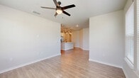 Located in Apopka, FL, this well-designed single-story, 2-bedroom, 2-bathroom home offers a clean, modern aesthetic with thoughtful finishes throughout. The open-concept kitchen and living area serves as the heart of the home, featuring a large central island with a white quartz countertop and an integrated sink, white upper cabinetry, contrasting gray lower cabinets, a herringbone tile backsplash, stainless steel appliances, and pendant lighting that adds warmth to the space. The living room is bright and airy, benefiting from multiple windows with outdoor views and a ceiling fan overhead. Wood-look luxury vinyl flooring runs consistently throughout, tying the spaces together. The spacious primary bedroom offers vaulted ceilings and natural light from windows, along with closet access. The second bedroom is also well-sized, featuring a ceiling fan and dual windows overlooking the outdoors. Both bathrooms are finished with clean, modern detailing—white quartz vanity tops, gray cabinetry, black hardware accents, large framed mirrors, and wood-look flooring. The primary bathroom includes a glass-enclosed walk-in shower, while the second bathroom features a tub-shower combination. Two closets and a hallway complete the practical, efficiently laid-out floor plan.