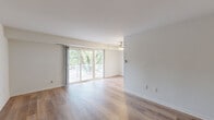 This 2-bedroom, 1-bathroom home in Odenton, Maryland offers a thoughtfully designed single-floor layout that balances comfort and functionality. The open living area is a standout feature, showcasing warm hardwood-style flooring, neutral walls, and a ceiling fan overhead. Sliding glass doors lead to a private balcony overlooking lush, mature trees, filling the space with natural light and serene outdoor views.

The kitchen is well-equipped with white shaker-style cabinetry, granite countertops, a corner undermount sink, and black stainless steel Whirlpool appliances, including a gas range, over-the-range microwave, and dishwasher. The hardwood-style flooring continues seamlessly into this space.

Both bedrooms are carpeted and feature large windows that frame tree-lined views, providing a bright and peaceful retreat. The primary bedroom includes a sliding-door closet, offering practical storage. The second bedroom is comfortably sized with easy access to the hallway.

The full bathroom is clean and functional, featuring a white vanity with modern hardware, a tub-shower combination, and hardwood-style flooring. A hallway connects all rooms, with an entrance foyer completing the layout. The overall ambiance is bright, clean, and move-in ready.