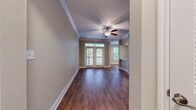 This 820 square foot apartment offers a harmonious blend of modern design and practical living. The space features two bedrooms, including a generous 160 square foot primary bedroom, and one bathroom. The open-concept living area is adorned with rich hardwood flooring, creating a warm and inviting atmosphere. Crown molding throughout adds an elegant touch to the space.

The kitchen is a highlight, boasting white cabinetry, granite countertops, and stainless steel appliances, including a spacious refrigerator and built-in microwave. A stylish tile backsplash complements the modern aesthetic. The bathroom features a double vanity with a large mirror and granite countertop, providing ample space for personal care.

Large windows, including an arched window in one of the bedrooms, flood the apartment with natural light. The living room opens onto a private balcony through French doors, perfect for enjoying outdoor views. Plush carpeting in the bedrooms ensures comfort underfoot.

Additional amenities include a ceiling fan for improved air circulation, in-unit laundry facilities, and multiple closets for storage. The neutral color palette throughout allows for easy personalization. This well-designed apartment offers a perfect balance of style and functionality in its efficiently laid out 820 square feet.