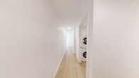 This thoughtfully designed two-bedroom, two-bathroom unit in Calgary's Mission neighbourhood offers a clean, modern aesthetic throughout. Light hardwood-style flooring flows continuously across the single-floor layout, complementing the crisp white walls and creating a cohesive, bright atmosphere.

The kitchen is a standout feature, equipped with full-height white cabinetry, a subway tile backsplash, stainless steel appliances including a refrigerator, range, and built-in microwave, plus a light quartz peninsula that opens toward the living area — ideal for casual dining or entertaining.

The primary bedroom is a comfortable, well-proportioned retreat with a large window providing natural light, and is accompanied by a dedicated ensuite bathroom. The ensuite features a double-sink vanity with quartz countertops, a glass-enclosed shower, built-in shelving, and hardwood-style flooring. The second bedroom also benefits from a large window with views of the surrounding neighbourhood.

A second full bathroom includes a soaking tub, white tile surround, and open shelving for added storage. Additional practical features include a dedicated closet with wire shelving and in-suite stacked laundry conveniently located off the hallway. The overall design prioritizes functionality and modern simplicity throughout.