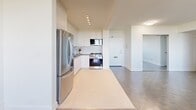 Located in North York, Toronto, this well-appointed 3-bedroom, 2-bathroom unit offers a thoughtfully designed layout across a generous single floor. The modern kitchen is a standout feature, outfitted with crisp white cabinetry, dark countertops, a classic subway tile backsplash, and a full suite of stainless steel appliances including a refrigerator, stove, microwave, and dishwasher. Track and recessed lighting illuminate the space with a clean, contemporary feel. The combined kitchen and living area flows naturally, creating an open and functional living space. Each of the three bedrooms is bathed in natural light from large windows framing treetop and city views, and feature checkered vinyl flooring. The primary bedroom includes mirrored sliding closet doors, adding depth and brightness to the room. The bathrooms are finished with white subway tile surrounds, soaker tubs, and chrome fixtures for a clean, timeless aesthetic. A private balcony accessible from the unit offers sweeping panoramic views of mature green parkland and the Toronto skyline — an exceptional outdoor retreat. Baseboard heating throughout ensures year-round comfort in this bright, move-in ready home.