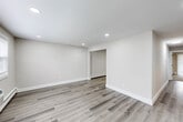 Located in Somers Point, NJ, this thoughtfully updated 2-bedroom, 1-bathroom single-floor residence offers a clean, modern aesthetic throughout. The open living area greets you with durable luxury vinyl plank flooring, recessed lighting, and a neutral color palette that creates a bright, welcoming atmosphere. Baseboard heating runs along the perimeter, and the space flows naturally toward the kitchen and bedroom areas.

The kitchen is a standout feature, showcasing charcoal-toned shaker cabinets with matte black hardware, crisp white quartz countertops, a subway tile backsplash, and a full suite of stainless steel appliances including a range, microwave, dishwasher, and refrigerator. The layout maximizes efficiency while maintaining an open feel.

The spacious primary bedroom features plush wall-to-wall carpeting, natural light from large windows, a wall-mounted AC unit, and a generous double-door closet. The second bedroom is similarly finished with carpet and ample natural light. The full bathroom impresses with a tub-shower combination, a rain showerhead, matte black fixtures, and a striking floor-to-ceiling mosaic tile surround. A dedicated laundry closet houses a stacked washer and dryer, adding everyday convenience to this well-appointed home.