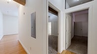 This 2-bedroom, 2-bathroom unit at 113-121 N 20th St, Unit 204 in Richmond, VA offers a well-designed single-floor layout with a blend of modern finishes and character-rich details. The open living room features warm hardwood flooring, bright white walls, and large windows that fill the space with natural light. It flows seamlessly into the kitchen and dining area, where a breakfast bar with pendant lighting, rich cherry wood cabinetry, granite countertops, and stainless steel appliances — including a range, microwave, and refrigerator — create a functional and attractive cooking space. The primary bedroom is a comfortable retreat highlighted by soaring ceilings with an exposed wood beam, adding architectural charm, along with plush carpeting and ample closet space. The second bedroom also features carpet flooring, a double-door closet with built-in shelving, and two windows that allow natural light. Both bathrooms are finished with tile flooring, full tub-shower combinations with white tile surrounds, and vanities with granite countertops. A dedicated utility room provides additional practicality. Throughout, the unit maintains a clean, neutral palette that offers a versatile canvas for personalization.