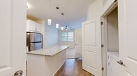 Located at 485 Crafton Cir in Charlottesville, VA, this single-floor residence offers two bedrooms and two full bathrooms in a thoughtfully designed layout. The open-concept kitchen serves as the heart of the home, showcasing white shaker cabinetry, granite countertops, a subway tile backsplash, stainless steel appliances including a refrigerator, dishwasher, microwave, and range, and a peninsula island with pendant lighting overhead. Hardwood-style flooring flows throughout the main living and kitchen areas, creating a warm and cohesive aesthetic. The living area transitions seamlessly from the kitchen and benefits from natural light and a ceiling fan. The spacious primary bedroom includes its own en-suite bathroom, which features granite countertops, white cabinetry, a glass-enclosed walk-in shower, hardwood-style flooring, and direct access to a walk-in closet with built-in shelving. The second bedroom is carpeted, bright, and well-sized, with a large window offering exterior views and a ceiling fan. The second bathroom mirrors the clean design of the primary bath, complete with granite counters, a soaking tub and shower combo, and access to an additional closet. The overall aesthetic is clean, modern, and neutral throughout.