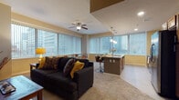 Located in the heart of Cleveland at 800 E Superior Ave, this single-floor residence offers a well-designed open-concept layout that seamlessly connects the living, dining, and kitchen areas. Large windows with vertical blinds throughout the space frame striking views of the downtown Cleveland skyline, flooding the interiors with natural light.

The spacious living room features plush carpeting, a ceiling fan, and ample room for comfortable seating arrangements. The kitchen is a standout, outfitted with warm wood cabinetry, granite countertops, stainless steel appliances including a refrigerator, microwave, and range, and a large center island with pendant lighting and bar seating — ideal for casual dining and entertaining.

Two well-proportioned bedrooms each offer carpeted floors, ceiling fans, closet storage, and large windows with city views, creating bright and restful retreats. The bathrooms are finished with tile flooring and granite vanity countertops; one features a walk-in glass-door shower with tile surround, while the other offers a granite-topped vanity with rich wood cabinetry. Throughout the residence, a warm neutral color palette and consistent finishes create a cohesive, polished ambiance suited for urban living.