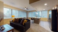 Located in the heart of Cleveland at 800 E Superior Ave, this single-floor residence offers a well-designed open-concept layout that seamlessly connects the living, dining, and kitchen areas. Large windows with vertical blinds throughout the space frame striking views of the downtown Cleveland skyline, flooding the interiors with natural light.

The spacious living room features plush carpeting, a ceiling fan, and ample room for comfortable seating arrangements. The kitchen is a standout, outfitted with warm wood cabinetry, granite countertops, stainless steel appliances including a refrigerator, microwave, and range, and a large center island with pendant lighting and bar seating — ideal for casual dining and entertaining.

Two well-proportioned bedrooms each offer carpeted floors, ceiling fans, closet storage, and large windows with city views, creating bright and restful retreats. The bathrooms are finished with tile flooring and granite vanity countertops; one features a walk-in glass-door shower with tile surround, while the other offers a granite-topped vanity with rich wood cabinetry. Throughout the residence, a warm neutral color palette and consistent finishes create a cohesive, polished ambiance suited for urban living.