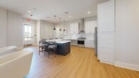Located at 2601–2609 Old Highway 31 in Columbia, Tennessee, this single-story space offers a well-organized and generously proportioned floor plan designed for both functionality and style. Light hardwood flooring flows continuously throughout, unifying the various areas and contributing to a warm, cohesive aesthetic.

The expansive living room is a standout feature, bathed in natural light through multiple large windows fitted with plantation-style blinds. The space easily accommodates multiple seating arrangements, with recessed lighting complementing the abundant daylight. A separate living area provides an intimate retreat, anchored by a wood-toned credenza, a large wall mirror with a gold frame, and access to a bright double-door window.

The kitchen is a modern showpiece, outfitted with crisp white cabinetry, quartz countertops, stainless steel appliances including a gas range with a wall-mounted hood, and a dark-toned island with bar seating beneath stylish pendant lights. An adjacent dining room offers a dedicated space for meals and gatherings.

A dedicated office or secondary room features a bold dark accent wall, wide windows with natural views, and a clean, focused atmosphere. Five connecting hallways ensure smooth circulation throughout the space, while two distinct entrances provide convenient access. The overall ambiance is modern, light-filled, and professionally appointed.