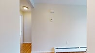 Located in Farmington, CT, this single-floor unit offers a clean, functional layout with consistent finishes throughout. Warm hardwood floors run through the living areas and bedrooms, lending a classic, polished look to the space. The living room is generously proportioned and benefits from abundant natural light through large sliding glass doors fitted with vertical blinds, which open to an outdoor view. Baseboard heating is found throughout, ensuring year-round comfort.

The galley-style kitchen is well-appointed with white shaker cabinetry, dark granite countertops, and a full suite of stainless steel appliances including a refrigerator, range, and over-the-range microwave. A pass-through window connects the kitchen to the dining area, creating an open, communicative flow between spaces. The dining area features the same warm hardwood flooring and offers direct access to a side entry door with additional natural light.

The bedrooms are bright and tranquil, each featuring hardwood floors, baseboard heaters, and windows that frame the surrounding greenery. The full bathroom is finished with a dark granite vanity top, white cabinetry, full-surround tiled tub/shower, and slate-toned tile flooring, providing a neat and functional space. Overall, the unit presents a well-maintained, move-in-ready environment.