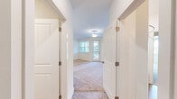 Located at 141 Inspiration Ave in Bluffton, South Carolina, this well-appointed single-story home offers four bedrooms and three full bathrooms across a thoughtfully designed floor plan. The kitchen is a standout feature, showcasing white shaker cabinetry extending to the ceiling, granite countertops, stainless steel appliances including a refrigerator, range, microwave, and dishwasher, and warm wood-look flooring — all illuminated by pendant lighting. The adjacent living room is bright and inviting, with large windows and a glass door that flood the space with natural light and provide access to an outdoor balcony. Bedrooms are carpeted for comfort, with multiple windows allowing ample natural light. The primary bedroom is generously sized and includes access to a dedicated closet. All three bathrooms mirror the kitchen's aesthetic with white cabinetry, granite countertops, large mirrors, and wood-look flooring. A dedicated in-unit laundry room includes a full-size washer and dryer with overhead shelving. Two hallways connect the rooms efficiently, and the clean, neutral palette throughout gives the home a bright, move-in-ready feel.