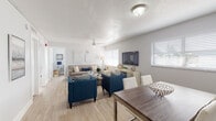 Located at 5301 NW 25th Ct in Lauderhill, Florida, this single-story home offers a thoughtfully designed layout with a bright, cohesive aesthetic throughout. Light wood-look flooring flows seamlessly across the main living areas, complementing the neutral gray-and-white color palette.

The open-concept living and dining area forms the heart of the home, bathed in natural light through multiple windows dressed with clean white blinds. A ceiling fan overhead adds comfort, while the generous layout easily accommodates both a full dining table and a comfortable living room arrangement.

The kitchen is a standout feature, showcasing slate-gray shaker-style cabinetry, granite countertops, a mosaic tile backsplash, and stainless steel appliances — a sleek, modern workspace well-suited for everyday cooking and entertaining.

The primary bedroom is a serene retreat, featuring light hardwood-style flooring, soft neutral tones, and a dedicated walk-in closet that provides ample storage. The full bathroom is clean and functional, complete with a tub-shower combination, a white vanity, and a framed mirror.

A versatile bonus room serves as a dedicated home office, filled with natural light from a large window — an ideal space for remote work or study. The overall ambiance of the home is welcoming, modern, and move-in ready.