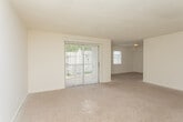 Located at 4103 Wesley Club Dr in Decatur, GA, this single-floor unit offers a practical and straightforward layout designed for comfortable everyday living. The open living area is generously sized, finished with neutral-toned carpet and light-colored walls that create a clean, bright atmosphere. A large sliding glass door with vertical blinds allows natural light to fill the space and provides an outdoor connection. An adjoining carpeted area extends the living space, offering flexibility for various uses. The kitchen is well-equipped, featuring warm oak cabinetry, white countertops, a white electric range, a dishwasher, and a sink — all set atop durable hardwood-style flooring. Multiple bedrooms are finished with plush carpet, textured ceilings, and windows that bring in natural light with views of the surrounding neighborhood. The bathroom includes a tiled tub and shower combination, a toilet, a vanity, and hardwood-style flooring, offering a clean and functional design. Throughout the unit, neutral tones and consistent finishes contribute to a cohesive and inviting atmosphere, making this a well-rounded space in a convenient Decatur location.