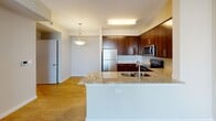 This single-floor residence offers a well-designed layout that balances modern finishes with functional living spaces. The kitchen serves as a standout feature, showcasing rich dark wood cabinetry, light granite countertops, and a full suite of stainless steel appliances, including a refrigerator, range, and microwave. A peninsula with an integrated double sink adds both workspace and a casual gathering point, while light hardwood-style flooring ties the kitchen and adjacent living area together seamlessly. The living area is generously proportioned, featuring large sliding glass doors fitted with vertical blinds that allow abundant natural light and outdoor views.

The bedrooms are finished with warm neutral carpeting and equipped with ceiling fans for added comfort. Windows dressed with horizontal blinds offer views of the surrounding community and greenery. The bathroom presents a clean, contemporary aesthetic, with large-format tile flooring, a dark wood vanity with a white sink, a wide mirror with overhead lighting, and a full soaking tub with a shower. Throughout the residence, neutral wall tones and consistent trim work create a cohesive, modern ambiance well-suited for comfortable everyday living.
