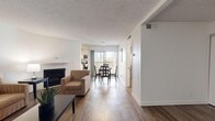 This thoughtfully designed 1-bedroom, 2-bathroom residence offers a functional and stylish single-floor layout. The open-concept living and dining area is anchored by rich hardwood-style flooring, a classic fireplace, and a textured ceiling that adds character throughout. The living room provides ample space for relaxing, with neutral tones and clean lines creating a bright, inviting atmosphere. Adjacent to the living area, the dining space comfortably seats four and features a sliding glass door that opens to an outdoor balcony, allowing natural light to pour in.

The kitchen is efficiently designed with white cabinetry, dark granite countertops, stainless steel appliances — including a gas range, built-in microwave, and dishwasher — and durable wood-style flooring, offering both practicality and a polished look.

The primary bedroom is a calm retreat featuring mirrored closet doors that enhance the sense of space, hardwood-style flooring, and direct access to a well-appointed bathroom. The bathroom showcases a dark granite vanity countertop, white cabinetry, and sleek chrome fixtures. An in-unit washer and dryer add everyday convenience. The overall ambiance is clean, modern, and move-in ready.