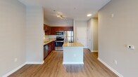 Located on Beacon Street in Raleigh, NC, this single-floor residence offers a well-designed open-concept layout that seamlessly connects the kitchen and living areas. The kitchen is a standout feature, showcasing rich cherry wood cabinetry, granite countertops with a classic subway tile backsplash, and a full suite of stainless steel appliances including a refrigerator, dishwasher, range, and microwave. A central island with matching granite provides additional prep space and casual dining options.

The living area is bright and welcoming, with hardwood-style flooring, neutral-toned walls, and a ceiling fan overhead. French doors open to an outdoor balcony, allowing natural light to flow freely into the space. The bedroom features plush carpeting, a ceiling fan, and direct balcony access through glass-panel doors, along with a closet equipped with wire shelving for organized storage.

The bathroom includes a full tub-shower combination with clean white tile surround and chrome fixtures. A dedicated laundry area houses a full-size washer and overhead wire shelving for added utility. Throughout the residence, consistent finishes, clean lines, and thoughtful details contribute to a cohesive and functional living environment.