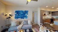 Located in the heart of Los Angeles' vibrant Arts District, this single-floor residence at 629 Traction Ave offers a thoughtfully designed modern living space. The open-concept kitchen is a standout feature, showcasing stainless steel appliances including a French door refrigerator, gas range with a sleek wall-mounted hood, and built-in microwave. Natural wood-tone cabinetry pairs with gray quartz countertops, while a geometric white tile backsplash and herringbone-patterned hardwood flooring add visual interest and texture.

The living area is bright and welcoming, with large sliding glass doors fitted with vertical blinds that allow abundant natural light. A ceiling fan overhead and curated décor lend the space a contemporary, artistic character.

The bedroom is generously proportioned, featuring carpet flooring, a ceiling fan, and a large window with outdoor views. It is complemented by a spacious walk-in closet outfitted with extensive wire shelving and hanging systems for organized storage.

The bathrooms are finished with marble-look tile flooring, wood-grain vanities with gray quartz countertops, and framed mirrors. One bathroom includes a soaking tub and shower combination, while the other offers a walk-in shower. Clean lines and neutral tones throughout create a cohesive, modern aesthetic.