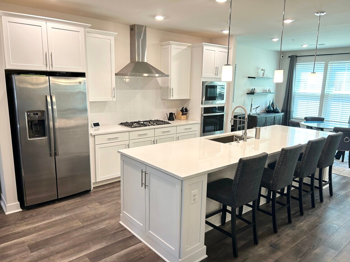 Kitchen features stainless steel appliances, gas range, large island, quartz countertops - 2330 Water Promenade Ave