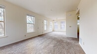 This single-floor residence offers a bright, functional layout designed for comfortable everyday living. The open living and dining area is carpeted throughout and filled with natural light from multiple windows, including a trio of windows in the dining nook highlighted by a classic pendant light fixture. A front entry door with flanking windows provides a welcoming entryway directly into the living space.

The galley-style kitchen features warm oak cabinetry, granite-look countertops, and light hardwood-style flooring. It is equipped with black appliances including a refrigerator and range, along with a dishwasher and a double sink. A window above the sink brings in additional natural light.

The bedrooms are carpeted and generously sized, each with ample wall space and good natural light. One bedroom benefits from dual corner windows with blinds, offering bright, airy conditions. A dedicated laundry area with hookups and additional storage is conveniently located within the unit.

Two full bathrooms are finished with oak vanities, granite-look countertops, and tub-shower combinations set against clean white surrounds. Hardwood-style flooring carries throughout the bathrooms and utility areas, providing a cohesive look. The overall aesthetic is clean, neutral, and move-in ready.