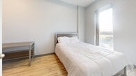 Located at 365 Albert St in Waterloo, Ontario, this efficiently designed unit offers a practical and comfortable single-floor layout. The open-concept living and kitchen area makes excellent use of the available space, with light hardwood-style flooring running throughout and neutral grey walls that create a clean, modern aesthetic.

The kitchen is well-appointed and fully functional, featuring light-toned shaker-style upper cabinetry contrasted by darker lower cabinets with granite-look countertops. Black appliances — including a full-size refrigerator, electric range, dishwasher, and built-in microwave — provide everything needed for everyday cooking. A subway tile backsplash adds a polished finishing touch. The adjacent open area provides ample room for a dining setup or living arrangement.

The bedroom is a calm, inviting retreat with warm hardwood flooring, soft grey walls, and a window that allows natural light to filter in, enhancing the sense of airiness. A desk area offers added functionality, making the room suitable for both rest and work.

The bathroom is neatly finished with large-format tile flooring, a dark wood vanity with a white basin sink, a framed mirror, and a well-maintained toilet. The space is compact yet complete, reflecting the same clean design language found throughout the unit.