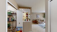 Located at 7036 Round Hill Dr in Waterford, Michigan, this single-floor residence offers a thoughtfully designed layout across a compact yet efficient footprint. The living room is bright and welcoming, featuring plush carpeting, neutral warm-toned walls, and a large sliding glass door framed by vertical blinds that floods the space with natural light and provides outdoor views. A versatile nook adjacent to the living area offers additional functional space, ideal for a home office setup. The kitchen features a galley-style design with rich wood cabinetry, light countertops, hardwood-style flooring, and full appliances, offering ample storage and a practical workspace. The generously sized primary bedroom includes soft carpeting, a large window with outdoor views, and direct access to a walk-in closet. Two bathrooms serve the home, both finished with classic mosaic tile flooring. The main bathroom includes a tub-shower combination and is decorated with clean, neutral tones. Throughout the home, a consistent warm beige color palette, white trim, and carpet in the main living areas create a cohesive and comfortable ambiance well-suited for everyday living.