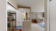 Located at 7036 Round Hill Dr in Waterford, Michigan, this single-floor residence offers a thoughtfully designed layout across a compact yet efficient footprint. The living room is bright and welcoming, featuring plush carpeting, neutral warm-toned walls, and a large sliding glass door framed by vertical blinds that floods the space with natural light and provides outdoor views. A versatile nook adjacent to the living area offers additional functional space, ideal for a home office setup. The kitchen features a galley-style design with rich wood cabinetry, light countertops, hardwood-style flooring, and full appliances, offering ample storage and a practical workspace. The generously sized primary bedroom includes soft carpeting, a large window with outdoor views, and direct access to a walk-in closet. Two bathrooms serve the home, both finished with classic mosaic tile flooring. The main bathroom includes a tub-shower combination and is decorated with clean, neutral tones. Throughout the home, a consistent warm beige color palette, white trim, and carpet in the main living areas create a cohesive and comfortable ambiance well-suited for everyday living.