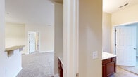 Located at 859 S Cliffs Cir in Spring Lake, NC, this single-floor, 2-bedroom, 2-bathroom home offers a practical and comfortable layout. The living area is spacious and bright, featuring plush carpeting, a ceiling fan, and French doors that invite natural light while opening to the outdoors. Neutral beige tones throughout the home create a clean, cohesive aesthetic.

The kitchen is well-appointed with warm wood cabinetry, granite-style countertops, a tile backsplash, and stainless steel appliances including a refrigerator, electric range, and built-in microwave. Tile flooring and a pendant light above the adjacent dining area add a polished touch.

The primary bedroom is generously sized, featuring carpet flooring, a ceiling fan, and a window with natural light. It connects to a bathroom with a wood vanity and a tub-shower combo. The second bedroom also features carpet, a ceiling fan, and a reach-in closet with built-in shelving. A second full bathroom mirrors the first in design and function.

A dedicated laundry room with washer and dryer hookups, wire shelving, and tile flooring adds convenience. The hallway, finished in hardwood-style flooring, connects the home's spaces efficiently, completing this well-organized and move-in-ready residence.