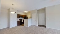 This single-floor residence offers a practical and comfortable layout designed for everyday living. The open-concept living area is finished with plush wall-to-wall carpeting and features a ceiling fan, creating a relaxed and airy atmosphere. The space flows naturally toward a peninsula-style kitchen, which is equipped with rich dark wood cabinetry, light countertops, black appliances including a refrigerator, range, and microwave, and durable hardwood-style flooring. A dedicated entry foyer with tile flooring provides a clean transition into the living space.

The two bedrooms are generously sized, each featuring soft carpeting, ceiling fans, and windows that invite natural light. One bedroom includes an open closet with a built-in rod for ample storage, while the other offers additional closet space.

Two bathrooms serve the unit. The full bathroom includes a single-sink vanity with dark wood cabinetry, a light stone countertop, a tub-shower combination, and wood-style flooring. The second bathroom is more compact, featuring a shower, toilet, and an overhead storage cabinet, also finished with wood-style flooring.

Throughout the unit, neutral tones, white trim, and clean lines create a cohesive and move-in-ready aesthetic.