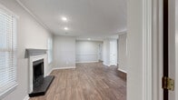 This single-story 2-bedroom, 2-bathroom home offers a thoughtfully designed layout with a clean, neutral aesthetic throughout. The open living room serves as the heart of the home, featuring rich wood-look flooring, recessed lighting, crown molding, and a classic fireplace with a white mantel — an ideal focal point for the main living area. A pass-through window connects the living space to the kitchen, enhancing the open feel.

The kitchen is well-equipped with white shaker-style cabinetry, granite countertops, a subway tile backsplash, a deep single-basin sink, and stainless steel appliances including a refrigerator and range. Wood-look flooring continues throughout this space, maintaining a cohesive design.

Both bedrooms offer plush wall-to-wall carpeting and soft gray walls, creating a calm and restful atmosphere. Natural light filters in through blinds-covered windows. The primary bedroom includes a dedicated closet with built-in shelving, while the second bedroom also benefits from its own closet access.

The two bathrooms are finished with granite-topped vanities and full tub-shower combinations with chrome fixtures. Wood-look flooring in the bathrooms complements the clean, white fixtures. Two hallways and two closets complete the functional layout of this comfortable single-floor home.
