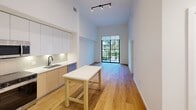 This contemporary 1-bedroom apartment in North Miami offers a generous 890 square feet of living space, including an expansive 430 square foot primary bedroom. The unit boasts a well-appointed kitchen, a luxurious bathroom, and a convenient hallway leading to a closet for ample storage.

The interior showcases modern design elements with clean lines and a neutral color palette. Light wood flooring runs throughout, creating a warm and inviting atmosphere. Large windows in the bedroom and living area flood the space with natural light and offer picturesque views of the lush tropical courtyard below.

The kitchen features sleek cabinetry in a combination of white and light wood tones, complemented by stainless steel appliances and a central island that doubles as a dining area. The bathroom exudes elegance with marble-like tiling, a glass-enclosed shower, and a floating vanity with ample storage.

Outside, residents can enjoy the meticulously landscaped courtyard, complete with palm trees, tropical plants, and a serene water feature. This oasis-like common area provides a perfect retreat for relaxation and socializing.

Located in Unit 105 - A1, this apartment is part of a larger complex that offers a resort-style living experience in the heart of North Miami, combining urban convenience with tropical charm.