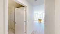 This 480 square foot apartment in Baltimore offers a thoughtful blend of functionality and style. The single-floor layout comprises a bedroom, bathroom, kitchen, and hallway, maximizing space efficiency. The primary bedroom, at 110 square feet, provides ample room for rest and relaxation.

The kitchen is a highlight, featuring sleek stainless steel appliances including a refrigerator, stove, and over-the-range microwave. Light wood cabinetry complements the modern aesthetic, while a soft green tile backsplash adds a touch of color. The countertops appear to be white quartz or a similar material, offering both durability and style.

The bathroom continues the modern theme with a expansive vanity, featuring ample storage and a large mirror. Clean lines and neutral tones create a spa-like atmosphere. Throughout the apartment, warm wood flooring adds warmth and ties the spaces together.

Large windows in the kitchen area allow for abundant natural light, enhancing the sense of spaciousness. The overall color palette of whites and light woods creates a bright, airy feel throughout the compact space, making it feel larger than its 480 square feet might suggest.