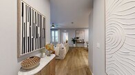 Located at 940 E Adams St in Jacksonville, FL, this thoughtfully designed two-bedroom, three-bathroom residence offers a cohesive blend of modern aesthetics and functional living. The open-concept kitchen and living area serves as the heart of the home, with the kitchen showcasing white flat-panel cabinetry, granite countertops, a classic subway tile backsplash, stainless steel appliances including a full-size refrigerator and built-in microwave, and light wood-look flooring that extends throughout the common areas. Track lighting overhead enhances the space's bright, contemporary character. The adjoining living room is generously proportioned, featuring a ceiling fan, large windows that invite natural light, and a neutral gray palette that creates a calm, inviting ambiance. Both bedrooms are carpeted and well-lit, each with ceiling fans, ample natural light from multiple windows, and access to dedicated closet space — including a walk-in closet with wire shelving. The three bathrooms are finished with wood-look tile flooring, glass-enclosed walk-in showers with large-format tile surrounds, white vanities, and refined fixtures. Each room reflects consistent attention to detail, making this a polished and comfortable residence in the heart of Jacksonville.