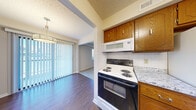 Located at 3109 Heritage Ct in Manhattan, Kansas, this single-floor home offers four bedrooms, three bathrooms, and a practical, well-organized layout. The kitchen is equipped with warm oak cabinetry, granite-style countertops, a white tile backsplash, a stainless steel double sink, and a full suite of appliances including an electric range and dishwasher. It opens directly into the dining area, which features rich hardwood-style flooring, a hanging light fixture, and a large sliding glass door with vertical blinds that brings in abundant natural light. The spacious living room is finished with plush carpeting, neutral walls, and a built-in wooden shelving unit, creating a comfortable and functional gathering space. The generously sized primary bedroom includes a ceiling fan, carpeted floors, and a walk-in closet with a hanging rod and shelving. Additional bedrooms are carpeted and feature ceiling fans and natural light. The three bathrooms include units with a tiled tub-shower combo and a standalone shower stall with hardwood-style flooring. Textured ceilings are consistent throughout the home. Two hallways connect the rooms efficiently, and a dedicated closet provides additional storage. The overall layout is practical and well-suited for comfortable everyday living.