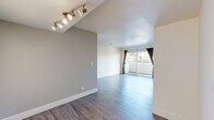 Located in the heart of Hollywood at 1250 N June St, this 2-bedroom, 2-bathroom unit offers a well-designed single-floor layout. The living room serves as the centerpiece of the space, featuring sleek hardwood-style flooring, a corner fireplace, and large sliding glass doors that open to a private balcony, flooding the room with natural light and providing outdoor views. A track lighting fixture adds a modern touch to the entryway area. The galley-style kitchen is efficiently laid out with rich dark wood cabinetry, light countertops, a double-basin sink, and black appliances including a gas range, offering ample storage and a clean, functional design. Tile flooring grounds the kitchen space. Both bedrooms are carpeted and feature large windows with views of the surrounding neighborhood, bringing in generous natural light. The primary bedroom is comfortably sized and includes dedicated closet space. The two bathrooms are finished consistently, each featuring light tile flooring, warm wood vanities with light countertops, and clean white fixtures. One bathroom includes a shower-tub combination. Hallways connect the rooms cohesively throughout the unit, completing this practical and comfortable Los Angeles home.