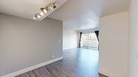Located in the heart of Hollywood at 1250 N June St, this 2-bedroom, 2-bathroom unit offers a well-designed single-floor layout. The living room serves as the centerpiece of the space, featuring sleek hardwood-style flooring, a corner fireplace, and large sliding glass doors that open to a private balcony, flooding the room with natural light and providing outdoor views. A track lighting fixture adds a modern touch to the entryway area. The galley-style kitchen is efficiently laid out with rich dark wood cabinetry, light countertops, a double-basin sink, and black appliances including a gas range, offering ample storage and a clean, functional design. Tile flooring grounds the kitchen space. Both bedrooms are carpeted and feature large windows with views of the surrounding neighborhood, bringing in generous natural light. The primary bedroom is comfortably sized and includes dedicated closet space. The two bathrooms are finished consistently, each featuring light tile flooring, warm wood vanities with light countertops, and clean white fixtures. One bathroom includes a shower-tub combination. Hallways connect the rooms cohesively throughout the unit, completing this practical and comfortable Los Angeles home.