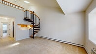 Located in Tarrytown, NY, this two-floor residence offers a thoughtfully designed layout with standout architectural details throughout. The main living area immediately impresses with soaring vaulted ceilings and a skylight that floods the space with natural light. A beautifully crafted spiral staircase with warm wood treads and black metal railings serves as a central focal point, connecting the two floors with both style and efficiency. Soft, neutral carpeting runs throughout the living and bedroom areas, creating a cohesive and comfortable feel.

The kitchen is well-equipped and practical, featuring warm oak cabinetry that extends to the ceiling for ample storage, light countertops, tile flooring, and white appliances including a range, refrigerator, and dishwasher. An integrated sink and under-cabinet lighting complete the functional setup.

The upper level hosts a generously sized bedroom with carpet flooring, a closet, and access to a full bathroom equipped with a soaking tub and shower surround. An additional room on this level benefits from a window with garden views. The entry area features a windowed front door beneath a vaulted ceiling, welcoming an abundance of natural light. Baseboard heating is present throughout the residence, ensuring year-round comfort.