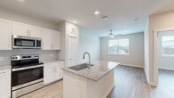 Located at 21932 Bellaire Blvd in Houston, TX, this single-story, one-bedroom, one-bathroom unit offers a thoughtfully designed layout with modern finishes throughout. Light wood-style flooring flows seamlessly across every room, creating a bright and cohesive aesthetic.

The kitchen serves as a central highlight, featuring a large island with granite countertops and an undermount sink, crisp white shaker cabinetry, a classic subway tile backsplash, and a full suite of stainless steel appliances including a French door refrigerator, range, over-the-range microwave, and dishwasher. The kitchen opens directly into the living area, which is brightened by a large window and accented with a ceiling fan.

The bedroom is a comfortable, well-lit space with a ceiling fan and a window that allows ample natural light. It connects conveniently to the full bathroom and a dedicated walk-in closet equipped with wire shelving for organized storage.

The bathroom is finished with granite-topped white vanity cabinetry and a tub/shower combination adorned with elegant marble-style tile surround, adding a refined touch to the space. The unit also includes an in-unit washer/dryer hookup area, providing added everyday convenience.
