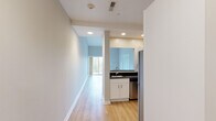 Located at 307 Central St in Hudson, Massachusetts, this single-floor residential unit offers a well-designed, open layout with a variety of functional spaces. The living area is a standout feature, boasting dramatic vaulted ceilings that create a generous sense of height and openness. Light hardwood-style flooring flows throughout the main living areas, complementing the neutral, light-toned walls. Sliding glass doors lead directly to a private balcony, providing outdoor views and natural light. Elegant French doors connect the living area to an additional room, adding versatility to the floor plan. The kitchen is outfitted with white shaker-style cabinetry, dark granite countertops, a breakfast bar pass-through, and a full suite of stainless steel appliances including a refrigerator, range, microwave, and dishwasher. A dedicated laundry area with a washer and dryer is conveniently located within the unit. The bedroom features plush carpeting, vaulted ceilings, and a window overlooking the surrounding greenery. The bathroom includes tile flooring, a glass-enclosed shower stall, and practical grab bar support. Recessed lighting throughout the unit ensures a bright and welcoming ambiance in every room.