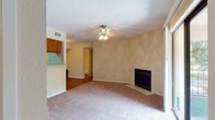 This single-floor residence offers a comfortable and functional layout designed for everyday living. The living room serves as the heart of the home, centered around a tiled fireplace and finished with plush carpeting underfoot. A ceiling fan with integrated lighting keeps the space comfortable year-round. A sliding glass door opens directly to a private balcony, allowing natural light to fill the room and providing a pleasant outdoor connection with views of surrounding greenery.

The kitchen is equipped with rich oak cabinetry, granite-style countertops, a double stainless steel sink, and black appliances including a range and dishwasher. Light hardwood-style flooring adds warmth, and a pass-through window connects the kitchen to the adjacent dining and living areas, enhancing the open feel of the shared spaces.

The bedrooms are generously sized, each featuring soft carpeting, ceiling fans, and ample natural light through window treatments. The rooms offer a calm, neutral atmosphere well-suited for rest or use as a home office.

Two full bathrooms serve the residence, each featuring a tub-shower combination with tiled surrounds, textured walls, wood-tone vanities, and hardwood-style flooring. The overall design is practical and inviting, with a consistent warm, neutral palette carried throughout the entire home.