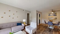 Located in Atlanta, GA, this 2-bedroom, 3-bathroom residence offers a thoughtfully arranged single-floor layout that balances comfort and functionality. The living room serves as a welcoming central hub, featuring wood-look flooring, neutral walls, and ample space for relaxed seating arrangements. Bold geometric curtains add a stylish accent, complementing the mid-century modern aesthetic carried throughout the home.

The adjacent dining area accommodates a full table and chairs beneath a ceiling fan with light fixture, making it ideal for everyday meals or entertaining. The kitchen is equipped with dark cabinetry, quartz-style countertops, subway tile backsplash, and stainless appliances including a gas range and refrigerator.

The primary bedroom is generously proportioned, featuring plush carpeting, a large window that invites natural light, and a textured ceiling detail. The second bedroom also features carpet flooring and clean, neutral finishes. A dedicated closet provides practical storage.

All three bathrooms are finished with white subway tile wainscoting, dark vanity cabinetry, quartz-style countertops, and framed mirrors — delivering a clean, cohesive look. Wood-look flooring in the bathrooms ties the design together seamlessly throughout the residence.