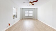 Located at 917 Jefferson St in Kansas City, Missouri, this single-floor unit offers a thoughtfully laid-out living space comprising a living room, kitchen, bathroom, and closet. The living room is bright and open, featuring light wood-style flooring, soft neutral-toned walls, multiple windows with blinds that invite natural light, a ceiling fan, and baseboard heating — creating a comfortable and airy atmosphere. The kitchen is well-appointed with modern grey cabinetry, white quartz countertops, a classic white tile backsplash, and a full suite of stainless steel appliances including a gas range, refrigerator, and dishwasher. A peninsula counter adds functionality and defines the transition between the kitchen and living area. The bathroom is clean and bright, finished with white tile flooring, a full soaking tub with an overhead shower, a window for natural ventilation, and a vanity with ample counter space. Light wood-style flooring flows throughout the main living areas, tying the space together with a cohesive, contemporary feel. The unit's efficient design maximizes every square foot, making it a practical and comfortable urban residence in the heart of Kansas City.